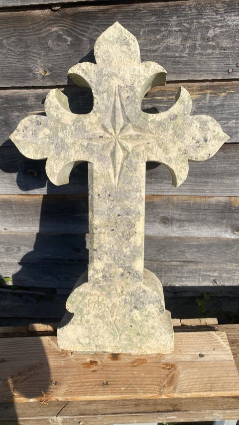 Croix en pierre sculptée couverte de lichens gris et verts avant nettoyage
