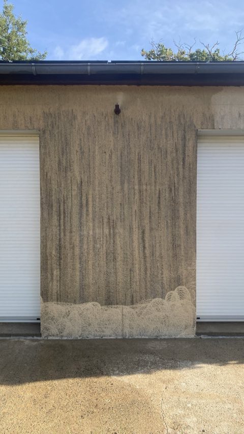 Mur enduit marqué de longues coulures sombres avant nettoyage
