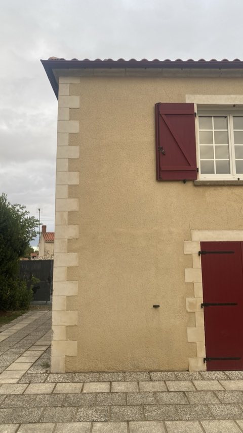 Le même angle de façade après nettoyage, enduit et pierres plus clairs